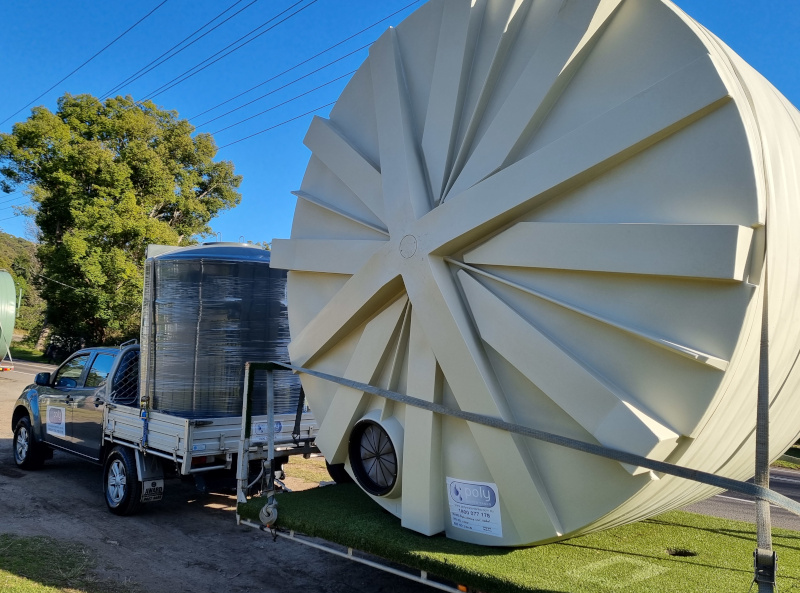 Delivery Ute & trailer loaded with two round water tanks